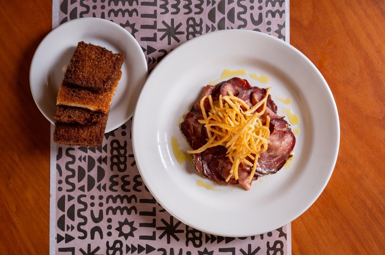 Tartar de lengua escarlata con yema curada y papas fritas, vista cercana