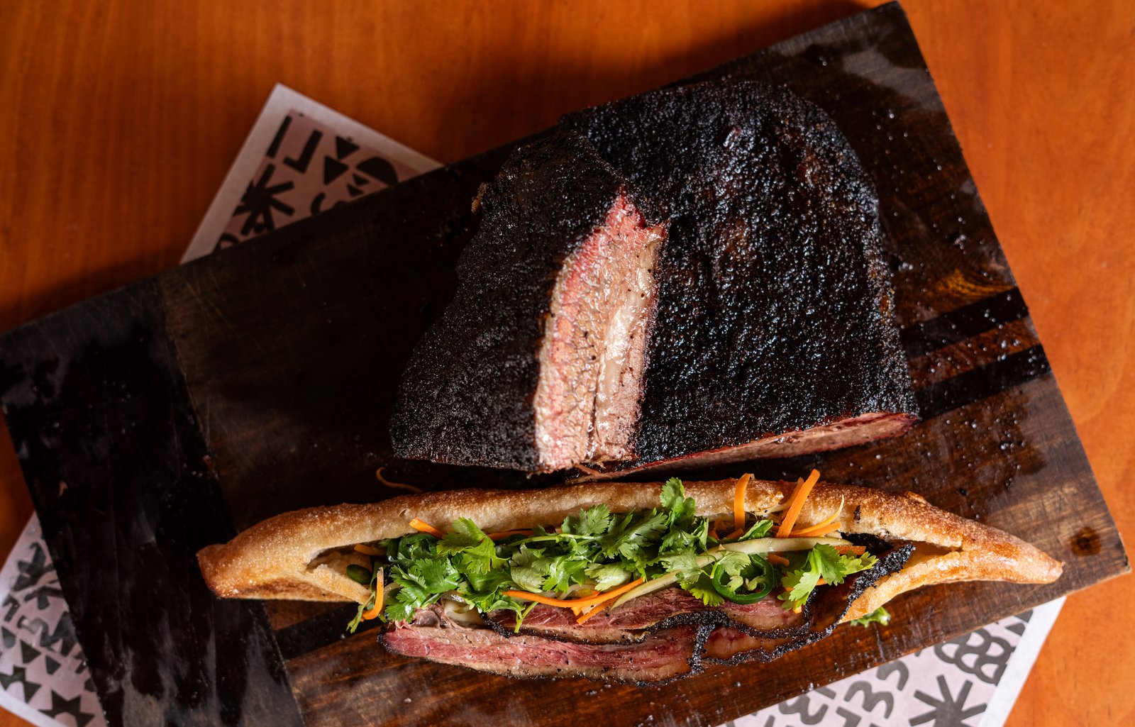 Bánh mì de brisket con los trozos de brisket ahumado al fondo