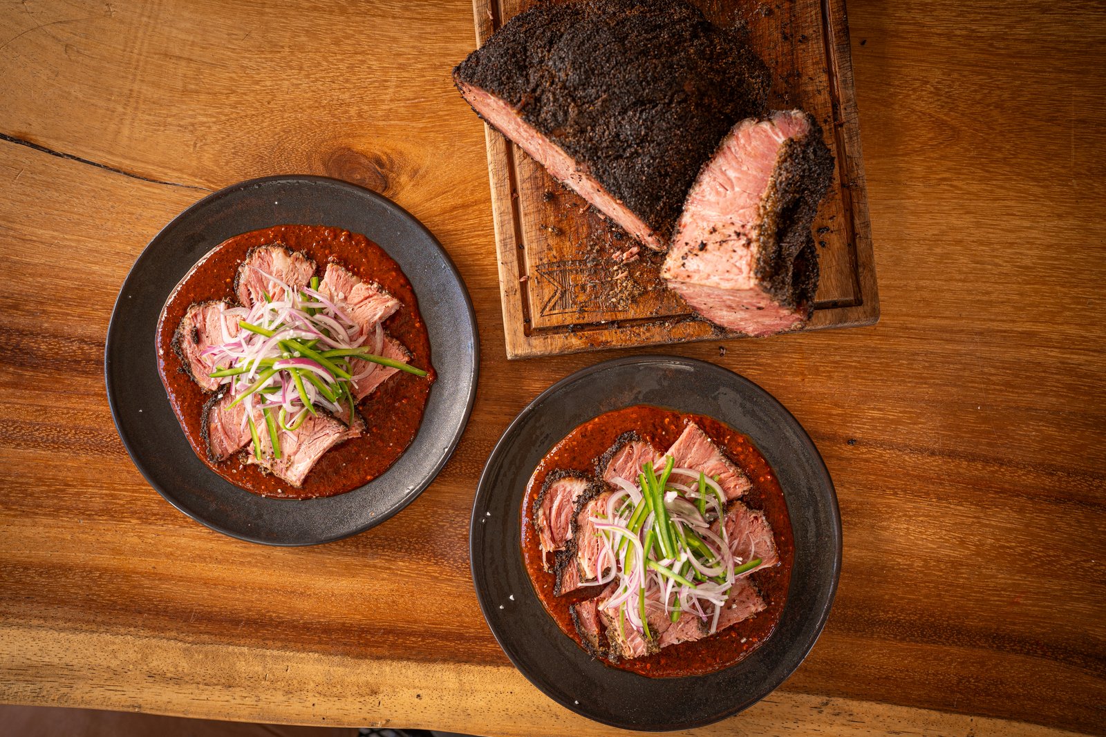 Aguachile de pastrami de joroba emplatado con salsa macha y cebolla morada