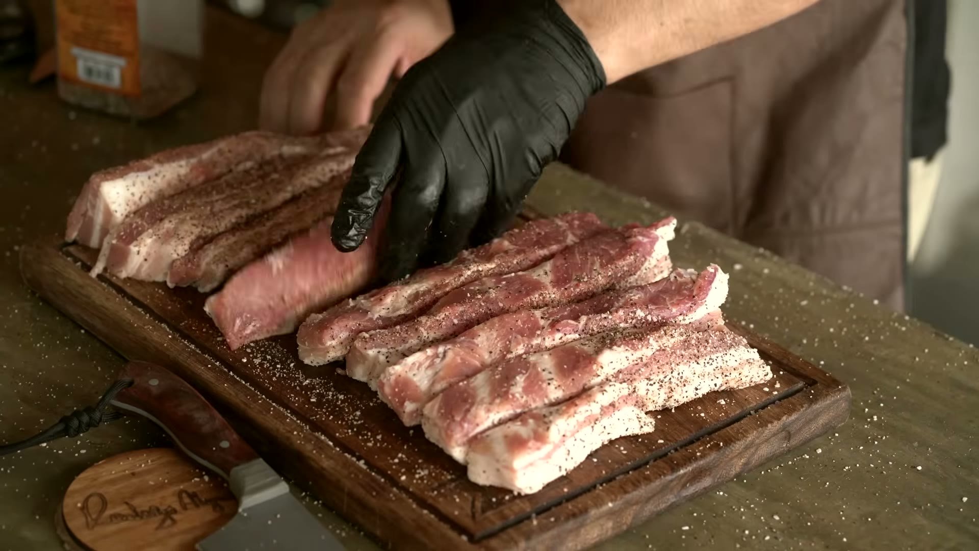 Tiras de pork belly en el ahumador con charola de agua