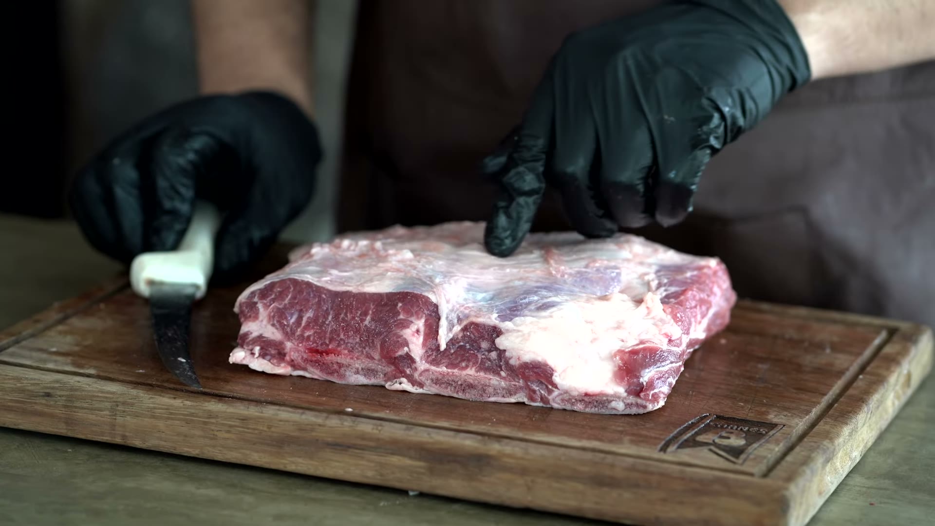 Aplicando sal y pimienta al short rib separado hueso por hueso