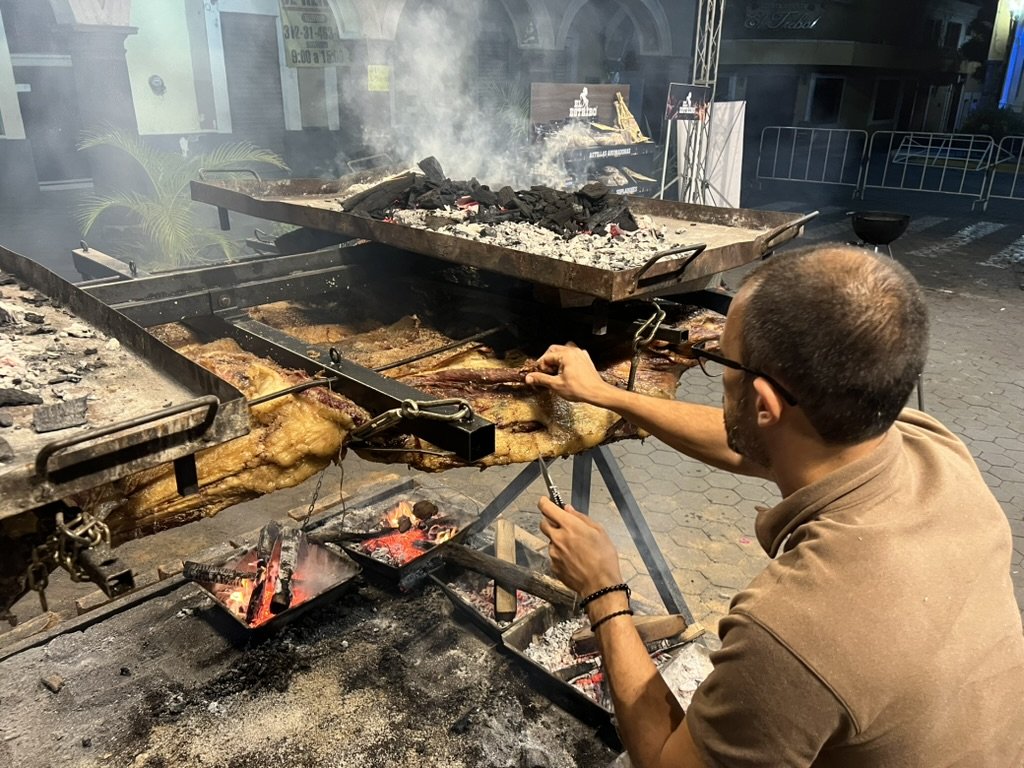 Atendiendo de cerca la carne sobre las brasas durante la madrugada