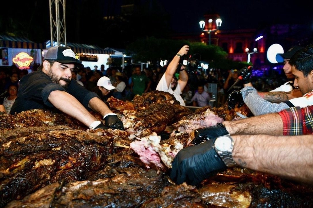 Partiendo la vaca entera para servir a la fila de gente